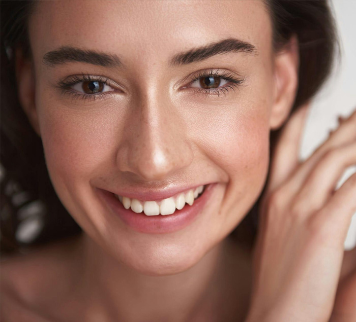 Close up portrait of happy smiling young brunette pretty lady with clean skin