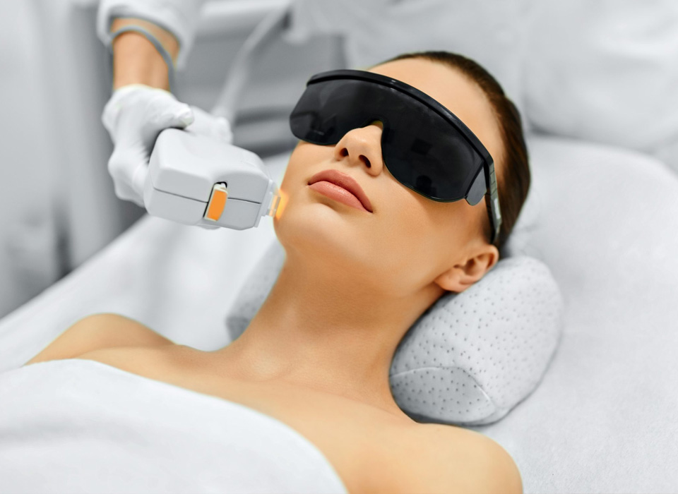Young woman receiving laser therapy on her face