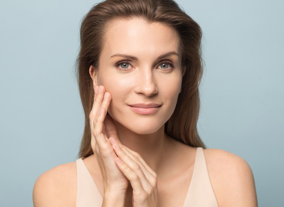 Close up portrait of beautiful young woman isolated on blue studio background