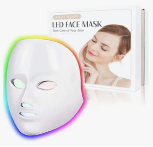 LED face mask with colorful edges, in front of a box featuring a woman smiling with eyes closed. Text: "Light Therapy LED Face Mask, Take Care of Your Skin."